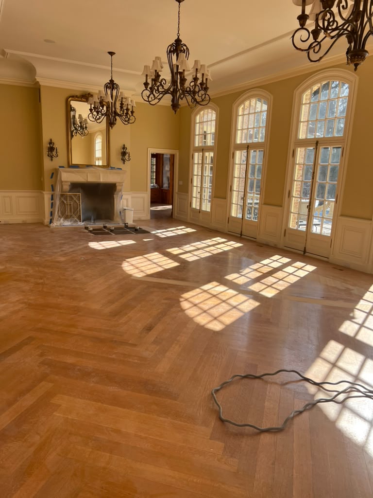 Herringbone hardwood floor sanded to raw wood before staining